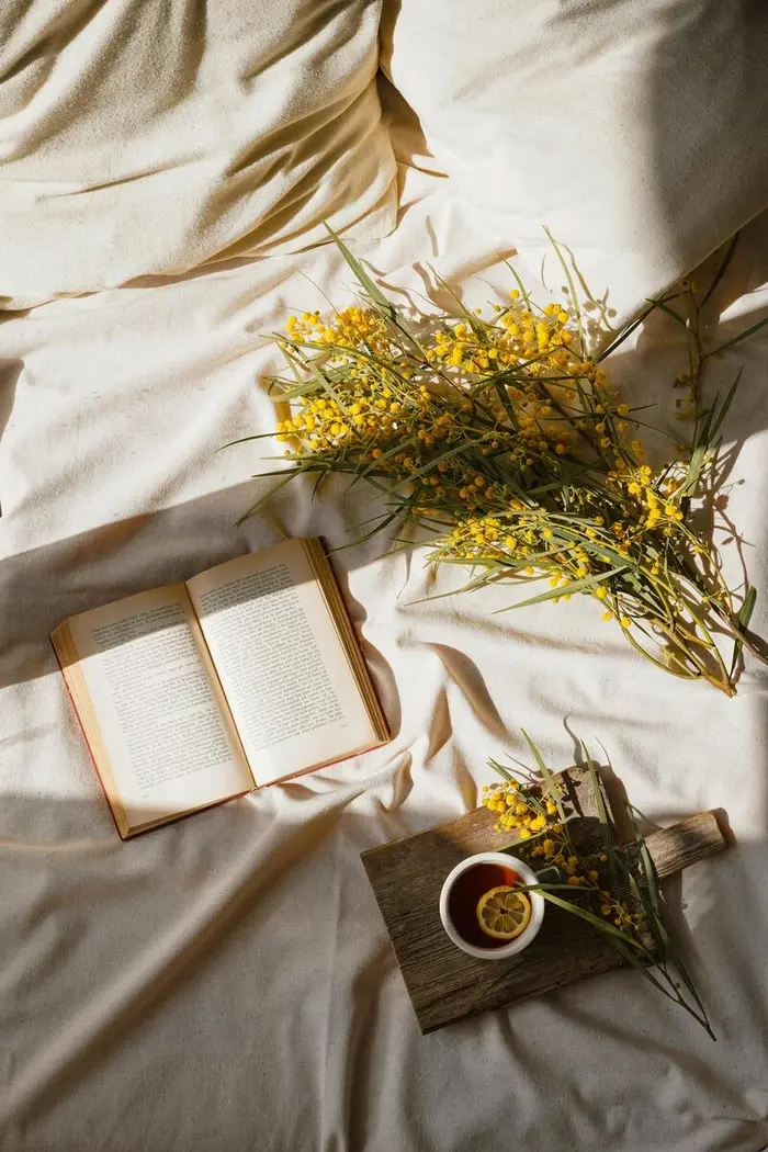 Tea and flowers on bed.