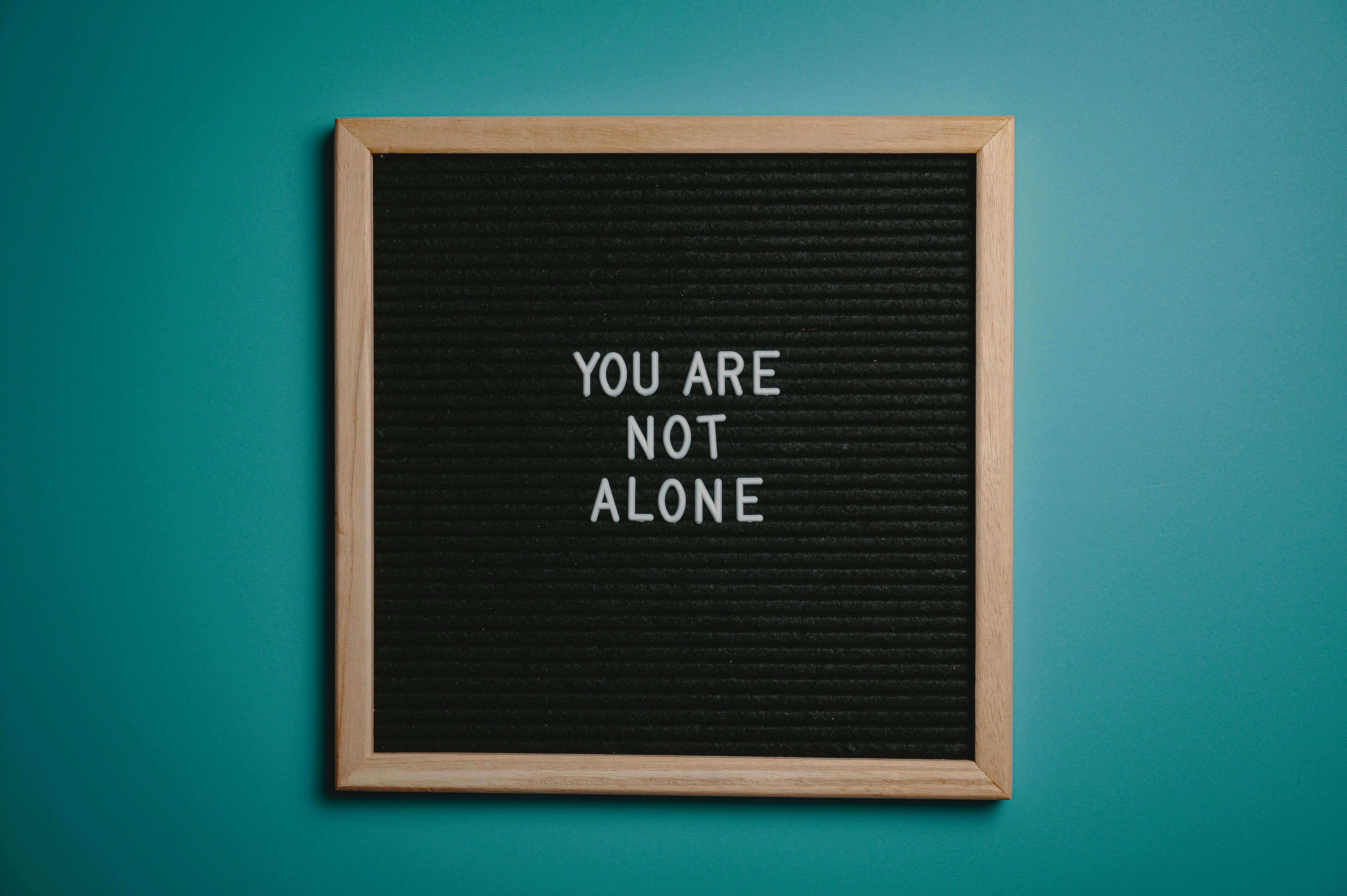 Wall sign that says 'You Are Not Alone'.